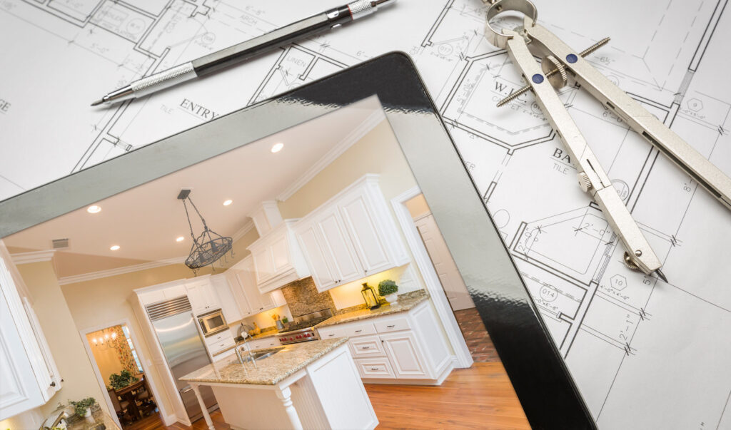 Computer Tablet Showing Finished Kitchen Sitting On House Plans With Pencil and Compass.